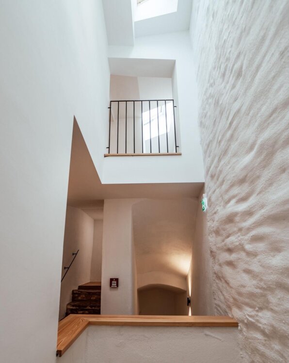 Moderne Treppenhausarchitektur mit weiß verputzten Wänden und Geländer.