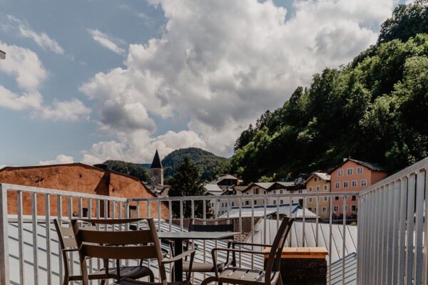 Terrasse eines Rooftop-Apartments von the salt mit Blick auf die Häuser in Hallein.