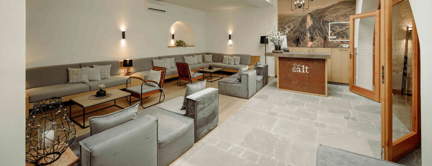 Gemütlicher, stilvoller Empfangsbereich im the salt townhouse Boutiquehotel mit modernen Sitzgelegenheiten und Holzbalkendecke.