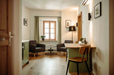 Helles Wohnzimmer mit modernen Möbeln, Holzboden und Pflanzen, gemütliche Atmosphäre.