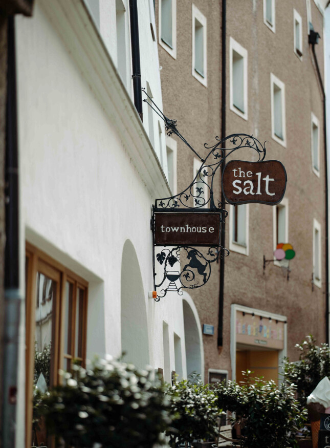 Außenansicht des the salt townhouse mit einem dekorativen Schild mit der Aufschrift "the salt townhouse" in einer malerischen Straße.