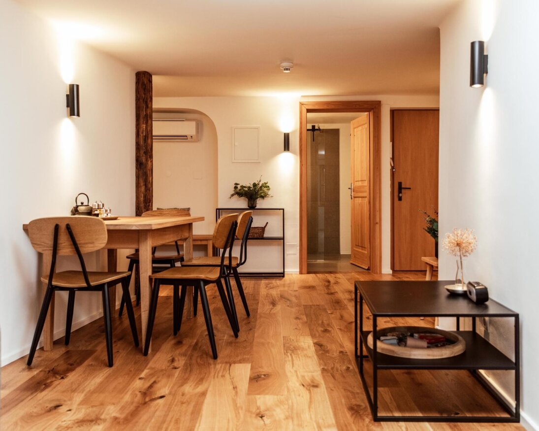 Ein moderner Sitzbereich mit Holzmöbeln, hellem Holzfußboden und stilvoller Beleuchtung in einem gemütlichen Raum.