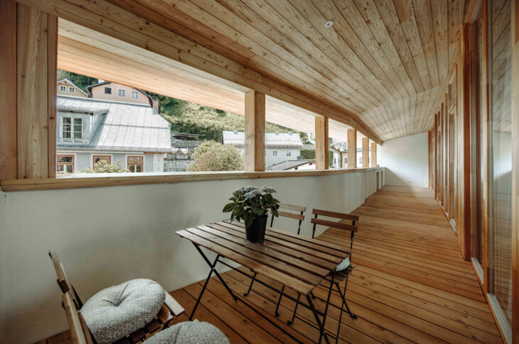 Großer, offener Holzbalkon mit Tisch und Stühlen im Galerie-Apartment von the salt Hallein.