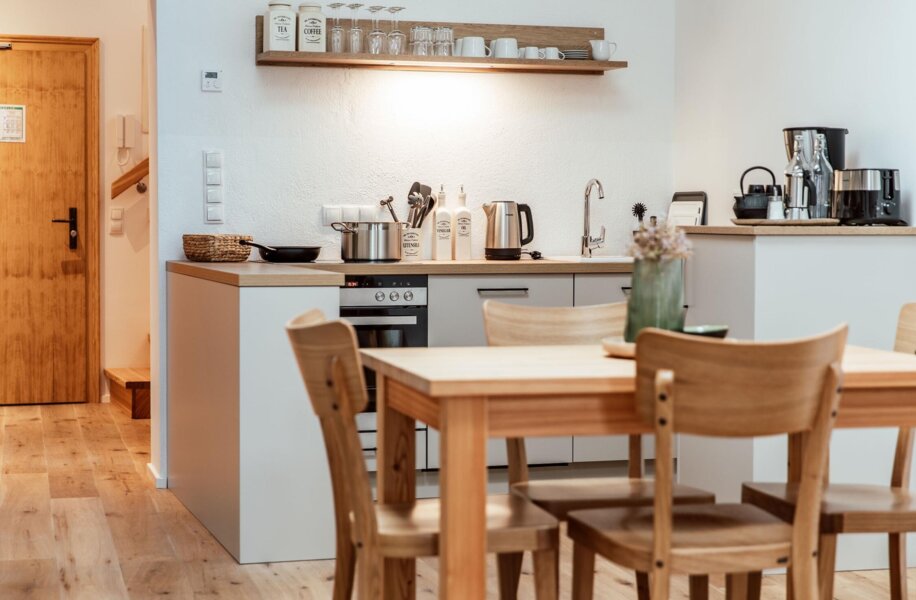 Voll ausgestattete Küche in einem the salt-Apartment mit Holzmöbeln und modernen Geräten.