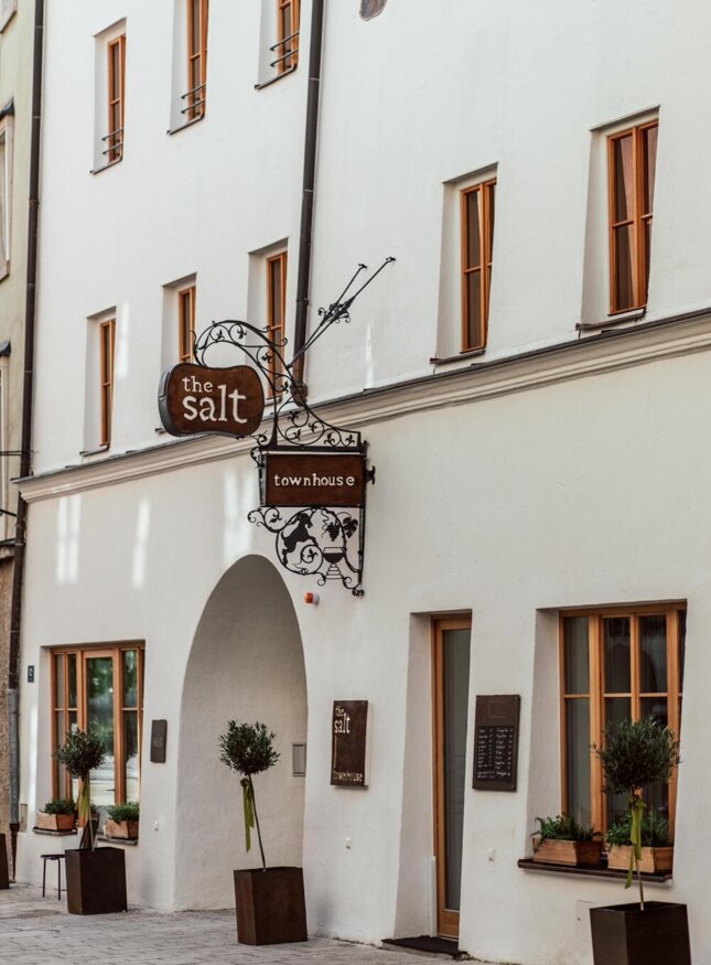 Fassade des the salt townhouse mit dekorativem Schild und Pflanzen vor dem Eingang in Hallein.