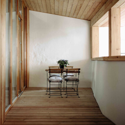 Balkon mit Holzmöbeln und Pflanzen des Galerie-Apartments von the salt Hallein.