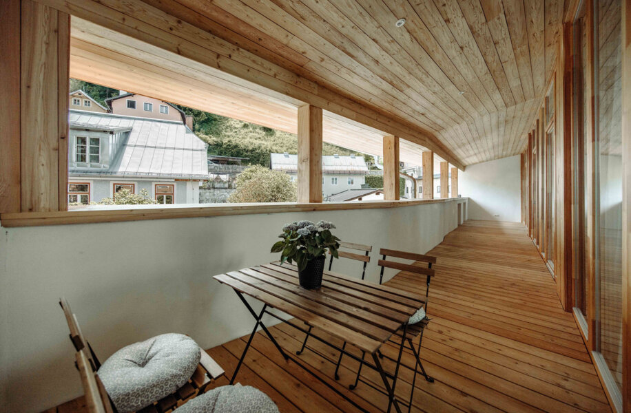 Großer, offener Holzbalkon mit Tisch und Stühlen im Galerie-Apartment von the salt Hallein.