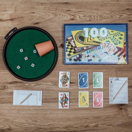 Brettspiele und Zubehör auf einem Holztisch, perfekt für gemütliche Abende in den stilvollen Apartments von the salt Hallein nahe Salzburg.