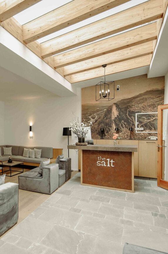 Gemütlicher, stilvoller Empfangsbereich im the salt townhouse Boutiquehotel mit modernen Sitzgelegenheiten und Holzbalkendecke.