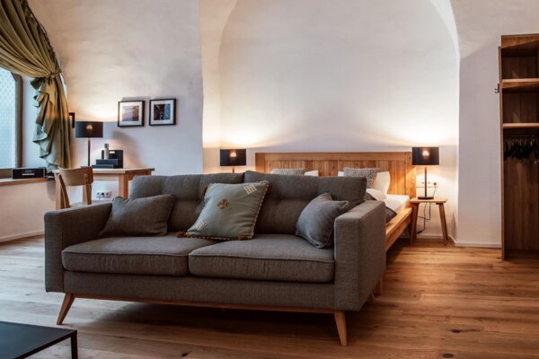Gemütliches, stilvoll eingerichtetes Apartment mit Sofa, Bett und Holzboden bei The Salt Hallein, ideal für Familienurlaub in Salzburg.