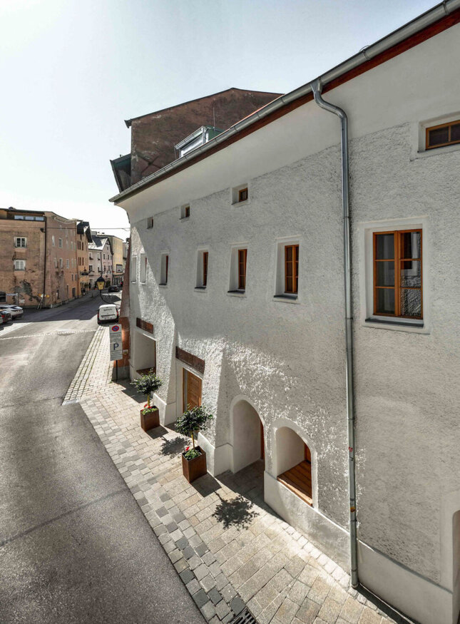 Straßenansicht des the salt vis à vis mit weißer Fassade und Holztüren in Hallein, Österreich, bei Tageslicht.
