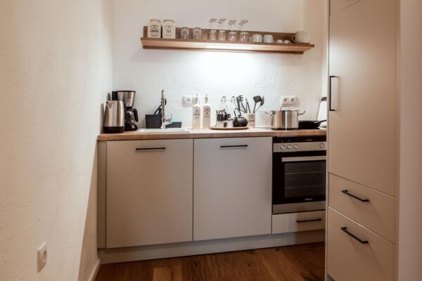Vollausgestattete Küche in einem Apartment von the salt mit Holzfußboden, modernen Geräten und stilvoller Einrichtung.