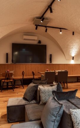 Großzügiger Veranstaltungsraum mit Gewölbedecke, modernen Möbeln und großem Bildschirm im the salt townhouse.