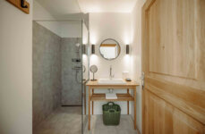 Stilvolles Badezimmer mit moderner Dusche, Holzdetails und gemütlichem Ambiente.