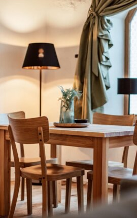 Essbereich mit Holzmöbeln und sanfter Beleuchtung.