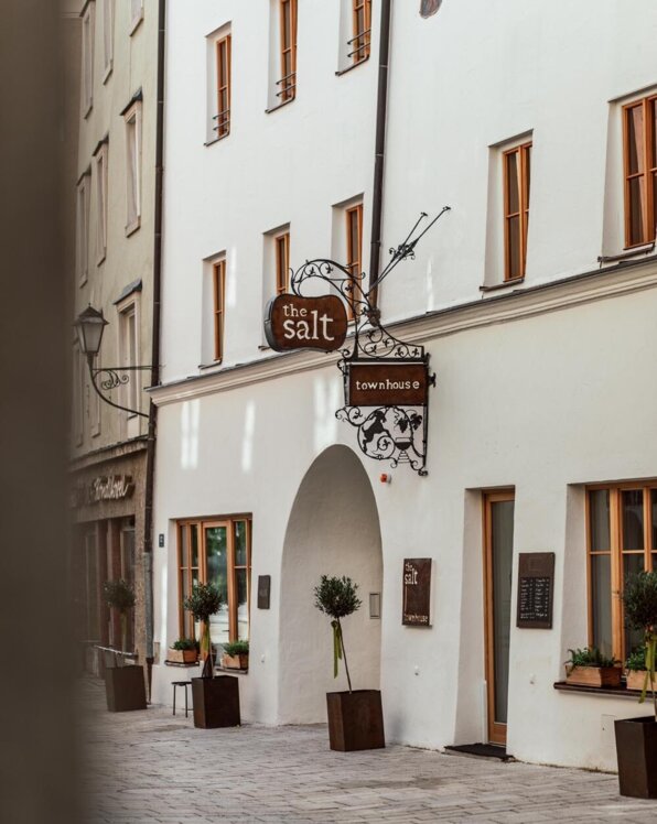 Eine malerische Gasse mit einem historischen Gebäude, das ein Schild mit der Aufschrift "the salt townhouse" trägt.