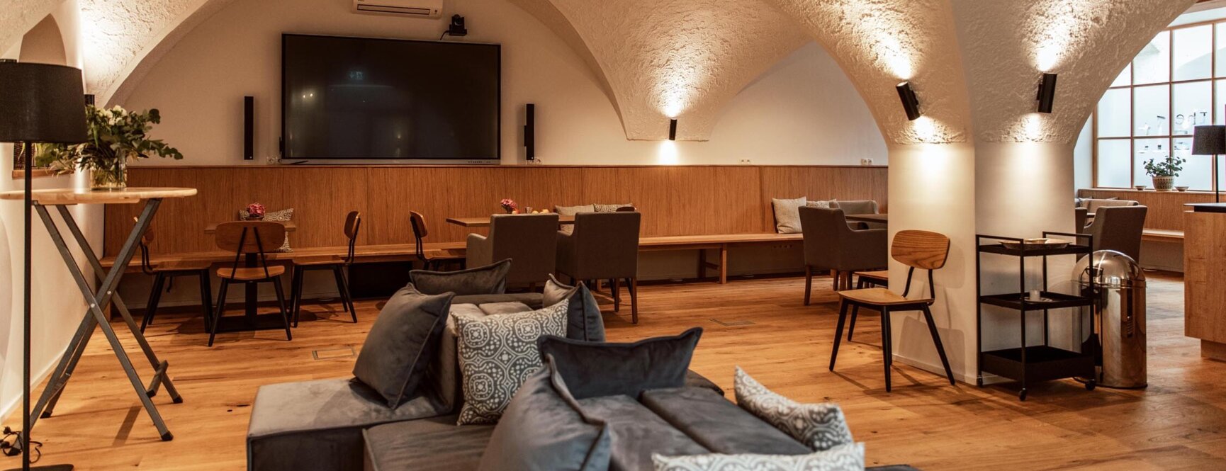 Großzügiger Veranstaltungsraum mit Gewölbedecke, modernen Möbeln und großem Bildschirm im the salt townhouse. 