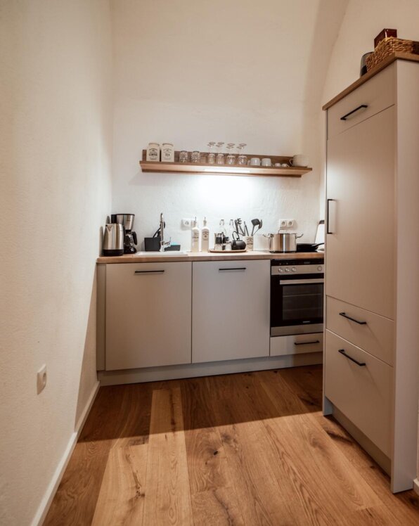 Vollausgestattete Küche in einem Apartment von the salt mit Holzfußboden, modernen Geräten und stilvoller Einrichtung.