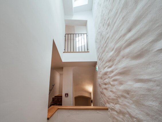 Moderne Treppenhausarchitektur mit weiß verputzten Wänden und Geländer.