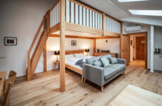 Wohnbereich eines the salt-Apartments mit Holzinterieur, Doppelbett, Loftbett, Sofa und moderner Ausstattung.