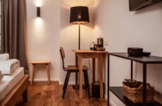 Cozy room with a wooden desk, chair, lamp, and decorative items.