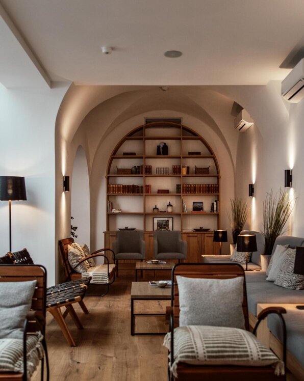 Eleganter Lounge-Bereich mit bequemen Sesseln, Bücherregalen und sanfter Beleuchtung im the salt townhouse.