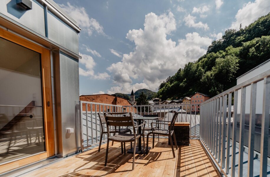 Terrasse eines Rooftop-Apartments von the salt mit Blick auf die Häuser in Hallein.