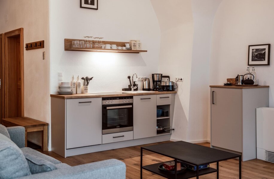 Küche mit modernen Geräten, Holzboden und minimalistischem Design in einem stilvollen Apartment.