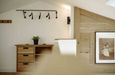 Stilvolle Einrichtung der Apartments mit Holzkommode, Pflanzen, Wandkunst und moderner Beleuchtung.