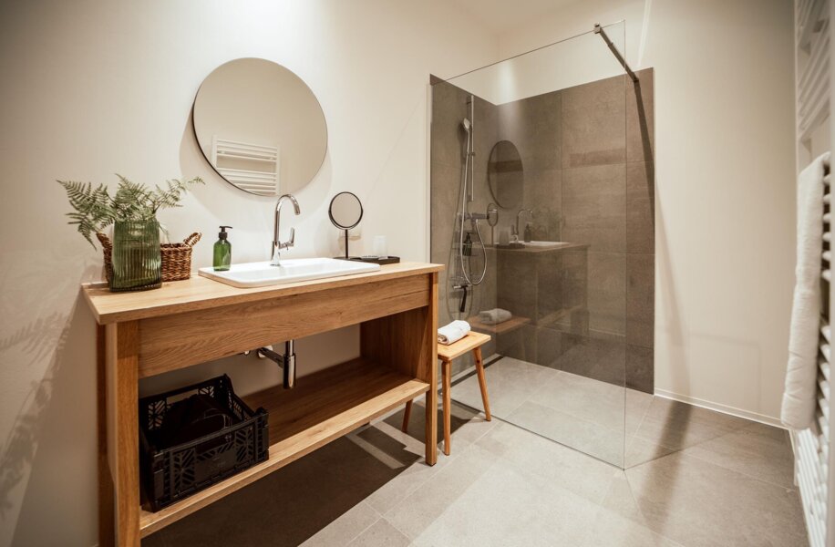 Modernes Badezimmer mit modernem Waschbecken, Spiegel und Dusche.