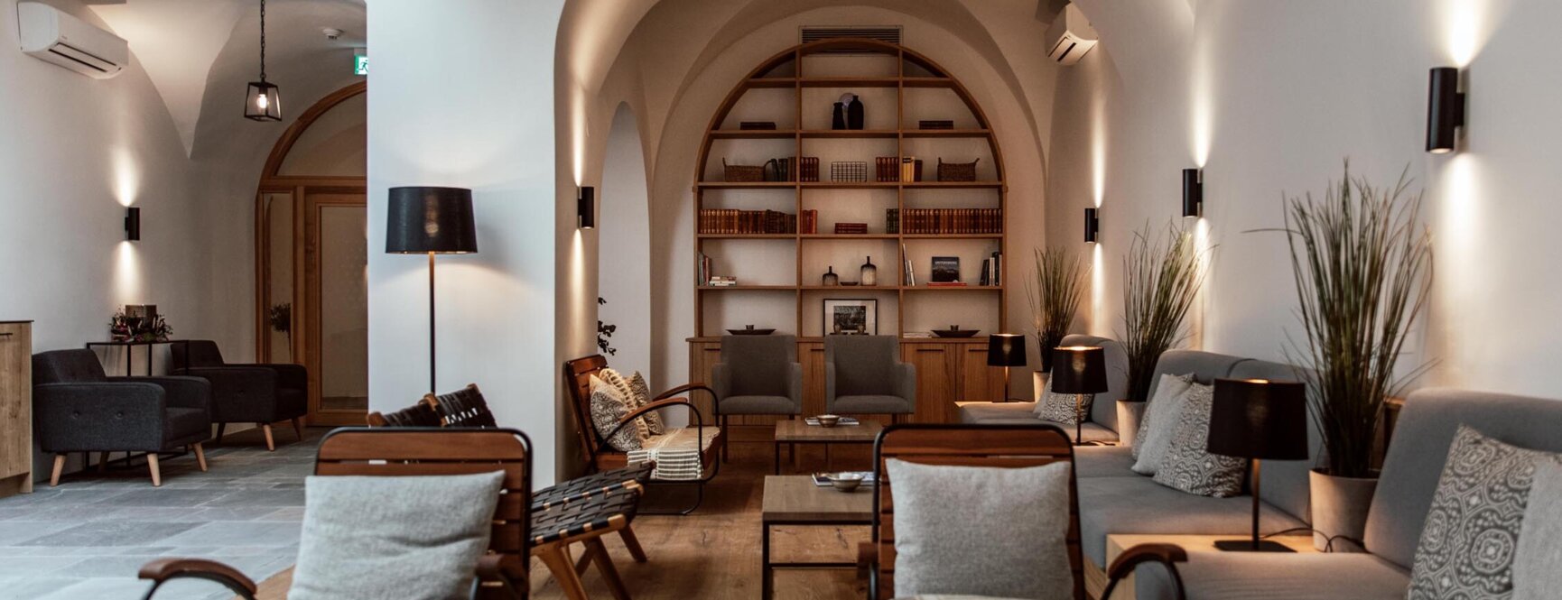 Modern lounge area at townhouse with cozy seating, ambient lighting, and a bookshelf in a stylish hotel setting.