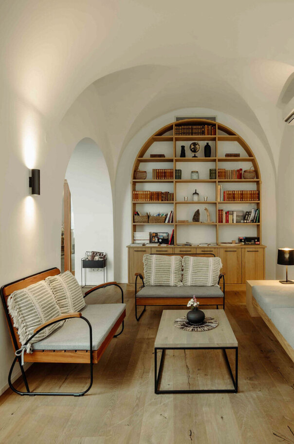 Sitzbereich im the salt townhouse mit gewölbter Decke, modernen Möbeln, Regalen und sanfter Beleuchtung.