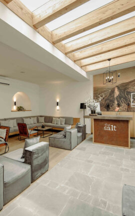 Gemütlicher, stilvoller Empfangsbereich im the salt townhouse Boutiquehotel mit modernen Sitzgelegenheiten und Holzbalkendecke.