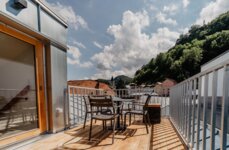 Terrasse eines Rooftop-Apartments von the salt mit Blick auf die Häuser in Hallein.