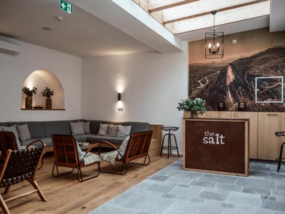 Gemütlicher Loungebereich im Boutiquehotel the salt townhouse mit moderner Einrichtung, Holzmöbeln und Kunst.