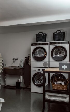 Waschraum mit Waschmaschinen und Trocknern der Gäste-Laundry in allen drei the salt Altstadthäusern.