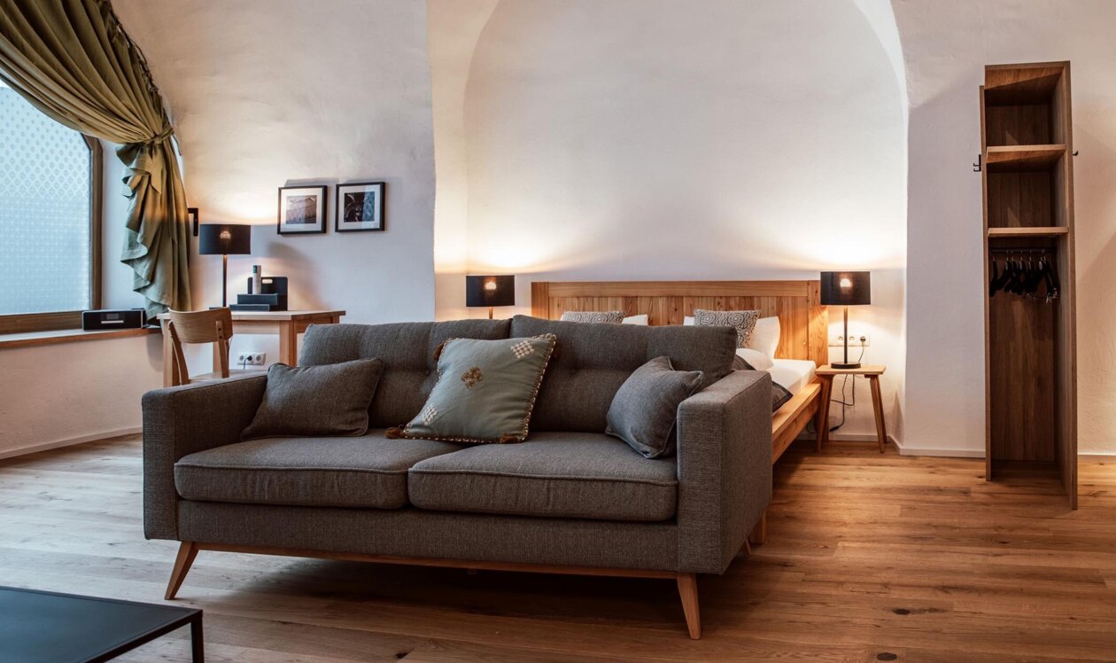 Gemütliches, stilvoll eingerichtetes Apartment mit Sofa, Bett und Holzboden bei The Salt Hallein, ideal für Familienurlaub in Salzburg.