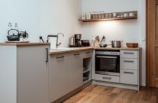 Voll ausgestattete Küche in einem the salt Apartment mit Holzarbeitsplatten und eingebauten Geräten.