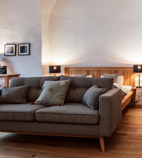 Gemütliches, stilvoll eingerichtetes Apartment mit Sofa, Bett und Holzboden bei The Salt Hallein, ideal für Familienurlaub in Salzburg.