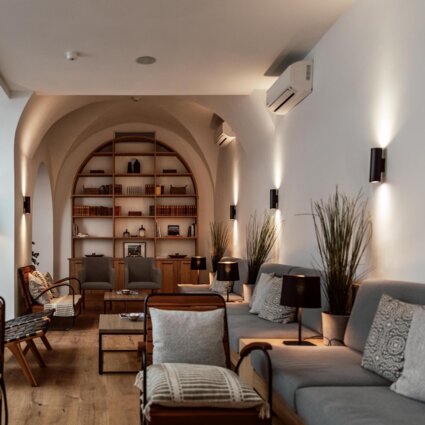 Eleganter Lounge-Bereich mit bequemen Sesseln, Bücherregalen und sanfter Beleuchtung im the salt townhouse.