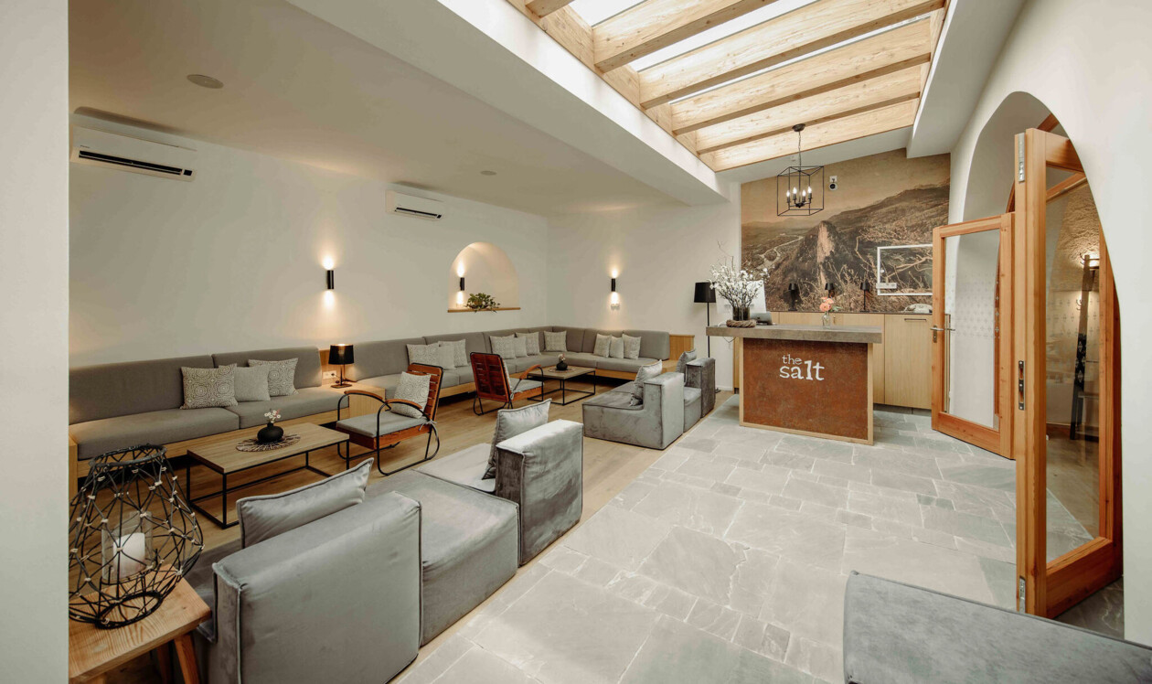 Gemütlicher, stilvoller Empfangsbereich im the salt townhouse Boutiquehotel mit modernen Sitzgelegenheiten und Holzbalkendecke.