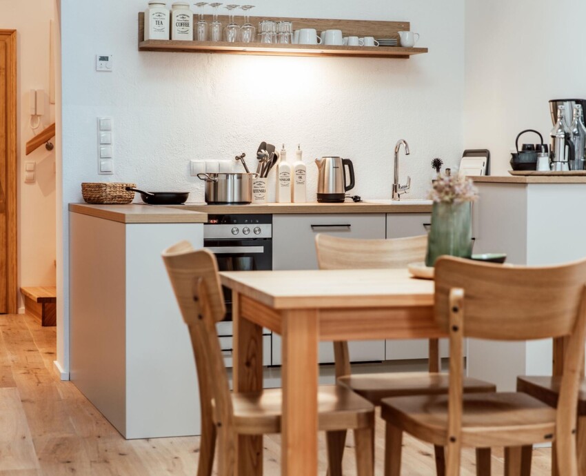Voll ausgestattete Küche in einem the salt-Apartment mit Holzmöbeln und modernen Geräten.
