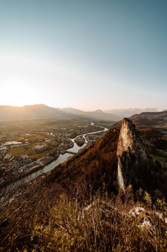 Blick auf Hallein mit Salzach und Berglandschaft im Sonnenuntergang.