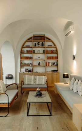Sitzbereich im the salt townhouse mit gewölbter Decke, modernen Möbeln, Regalen und sanfter Beleuchtung.