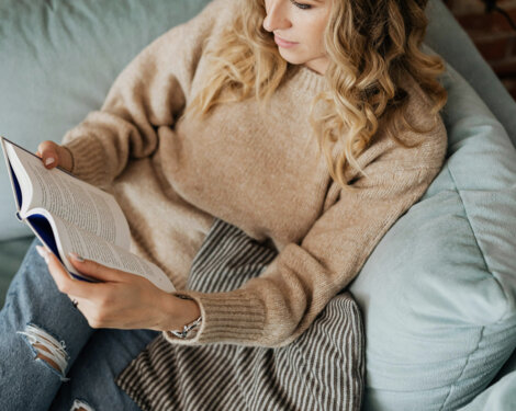 Eine Person liest gemütlich ein Buch auf dem Sofa im the salt Hallein.